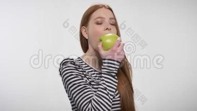 年轻的甜姜女咬着大苹果，享受它，提供，交流理念，白色背景